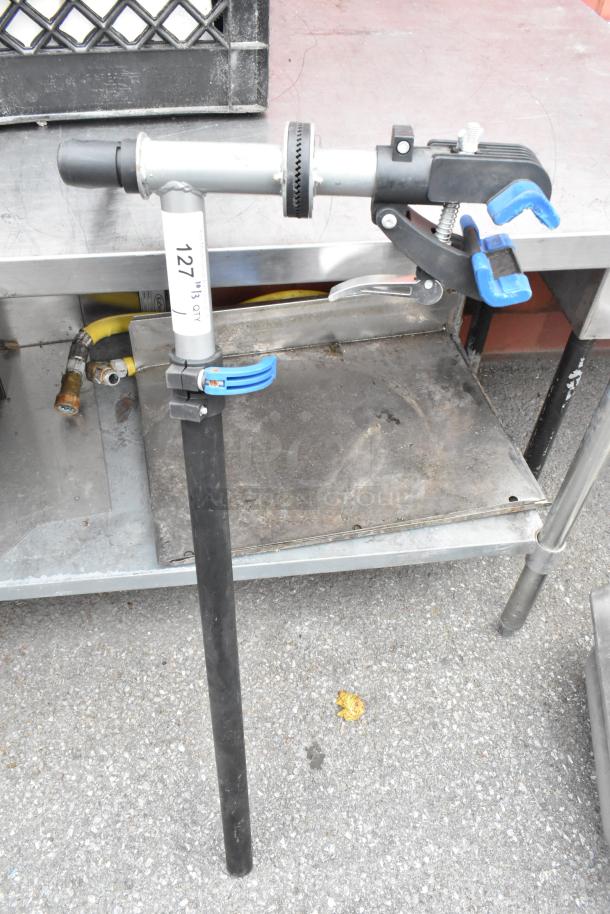 Clamp with adjustable stand, metal and plastic construction, labeled "127," in used condition. Suitable for secure holds.