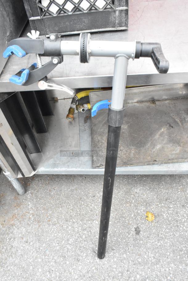 Clamp with stand, adjustable features, black and silver. Shows light wear, sturdy grip. Suitable for various applications.