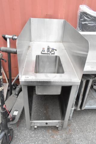 Stainless steel commercial single bay sink with faucet and handles, attached to a metal frame. Model number 128 visible.