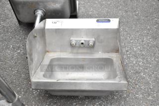 Stainless steel single bay sink with side splash guards, featuring a label from "amtekco," slightly worn condition.