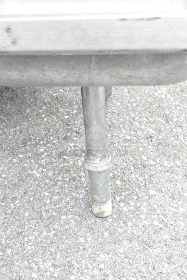 Stainless steel single bay sink with faucet. Visible pipe connection on the underside. Good condition.