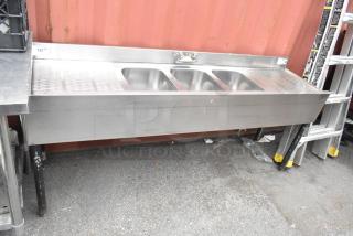 Stainless steel 3-bay back bar sink with dual drain boards, sturdy condition, ideal for commercial use.
