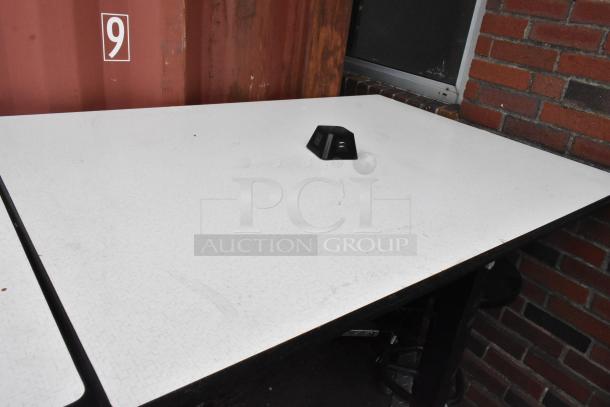 Three tables with white tops and attached stools, sizes 30x36x46 and 51x36x46, in used condition, metal frame.