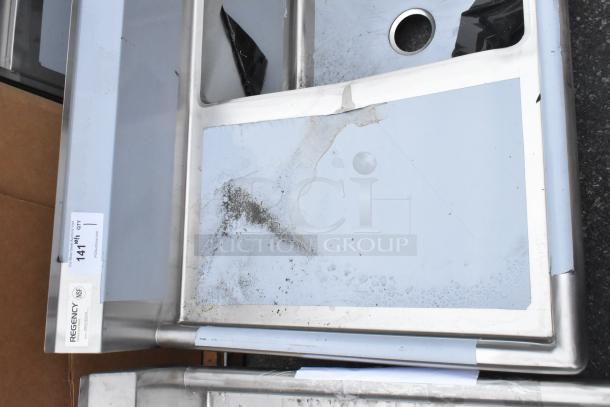 "Regency 600S31824218 stainless steel commercial 3 bay sink with dual drain boards, brand new, visible scratches and dents."