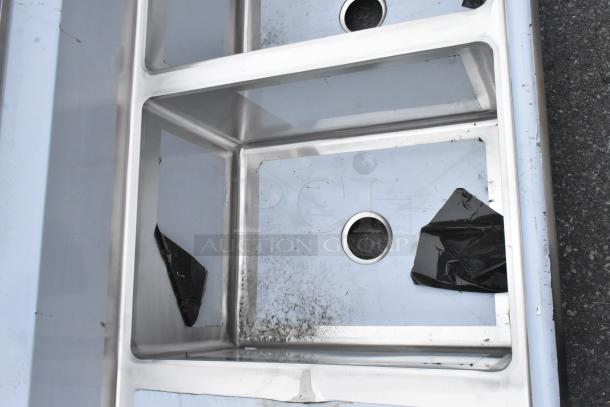 Brand new Regency 600S31824218 stainless steel 3-bay sink with dual drain boards, minor scratches, commercial-grade.