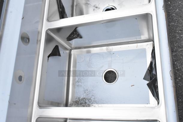 Stainless steel Regency 600S31824218 commercial 3-bay sink, dual drain boards, minor scratches, new condition.