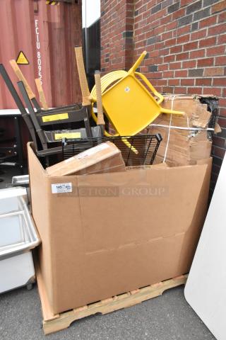Box with wire shelves, chairs, and various items marked as scratch and dent. Includes yellow chair and wrapped packages.