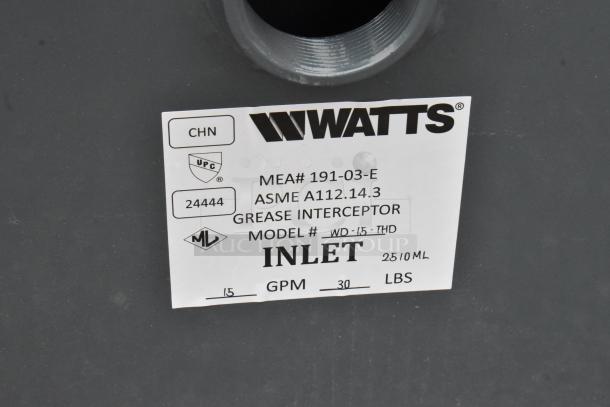 Brand new Watts WD-15-THD grease trap, 30 lb. capacity, with threaded connections. Features label detailing model and capacity.