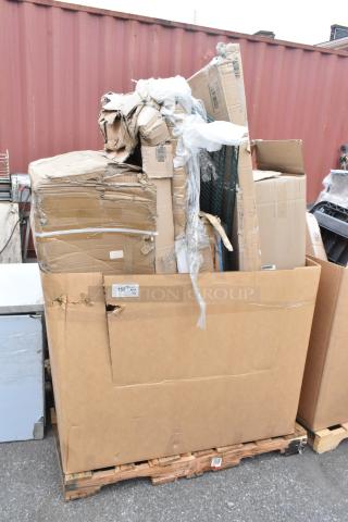 Stack of damaged cardboard boxes on a pallet, marked "152 H", containing scratch and dent items like dish table, pan rack.