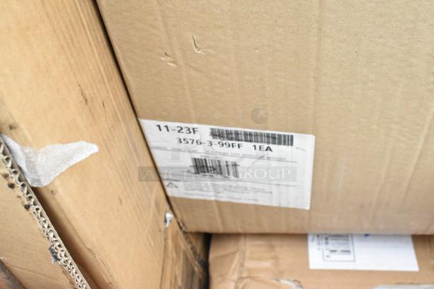 Cardboard boxes containing 13 brand new scratch and dent items, including a dish table, pan rack, and desk. Labels with barcodes visible.