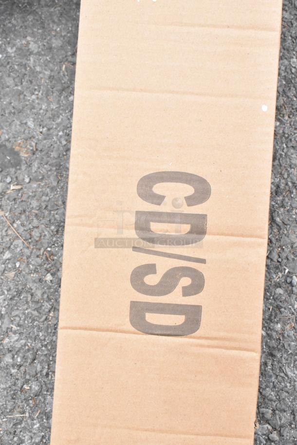 Cardboard packaging marked "CD/SD" for a Regency 600CDT24R 16 Gauge 2' Clean Dish Table, right drainboard, scratch and dent condition.