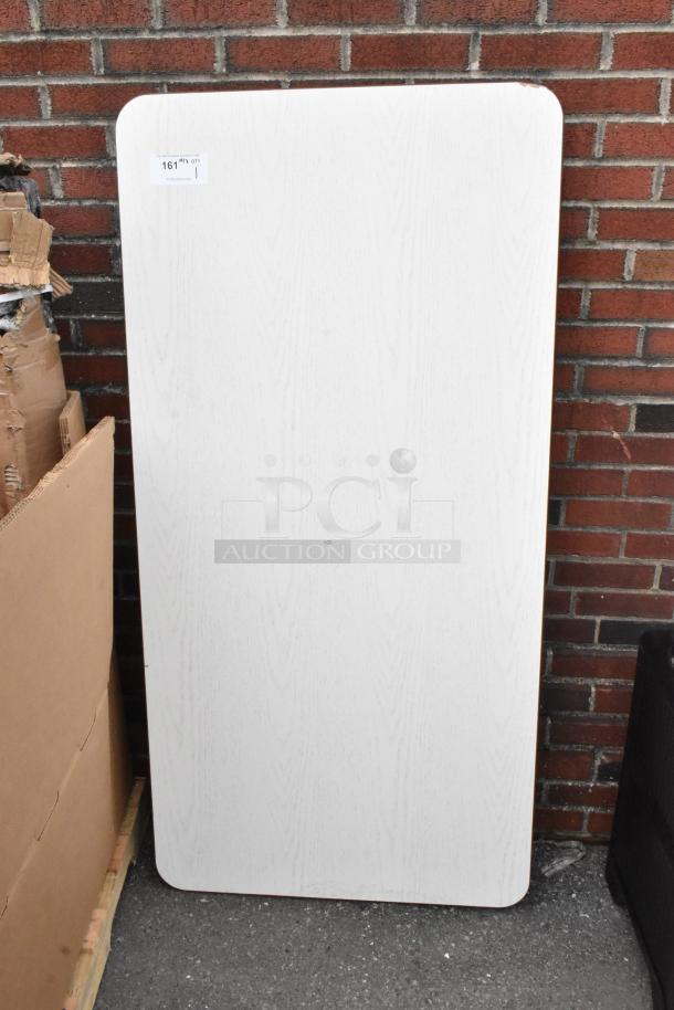 Brand new gray wood pattern tabletop with minor scratches. Rectangular shape, item label marked "161."