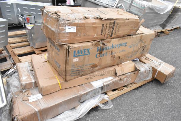 Boxes of brand new scratch and dent items include Lavex housekeeping cart, Regency stainless steel table, and table base.