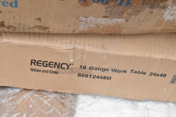 Cardboard box labeled "Regency 18 Gauge Work Table 24x48, 600T2448G" with visible wear and tear.