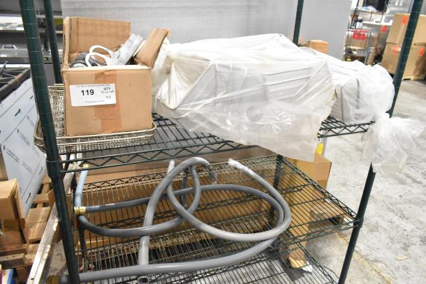 Two-tier lot with various items including metal baskets, boxed items, wrapped equipment, and hoses on metal shelving. Tag reads "119."