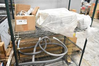 Two-tier lot with various items including metal baskets, boxed items, wrapped equipment, and hoses on metal shelving. Tag reads "119."