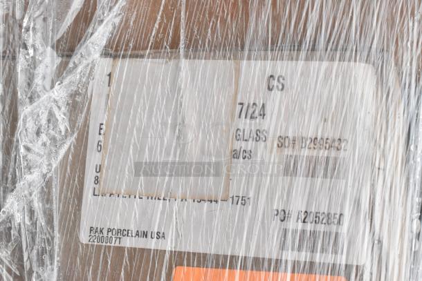 Plastic-wrapped box labeled "RAK Porcelain USA" with codes, part of auction including scratch and dent items like bath tissue dispensers.