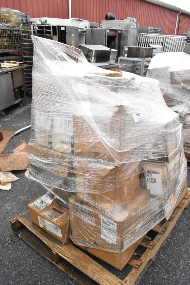 Shrink-wrapped pallet of 24 new scratch and dent boxes, including therapy bowls, plates, pot brush, and cooling plates. Fragile labels visible.