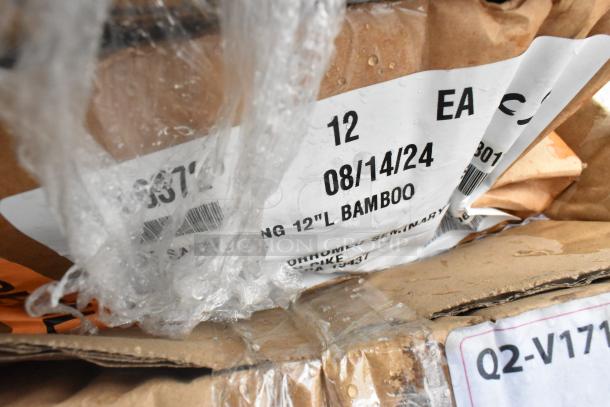 Close-up of a box with a label reading "12 EA, 08/14/24, 12''L BAMBOO." Slightly damaged packaging. Part of a scratch and dent auction lot.