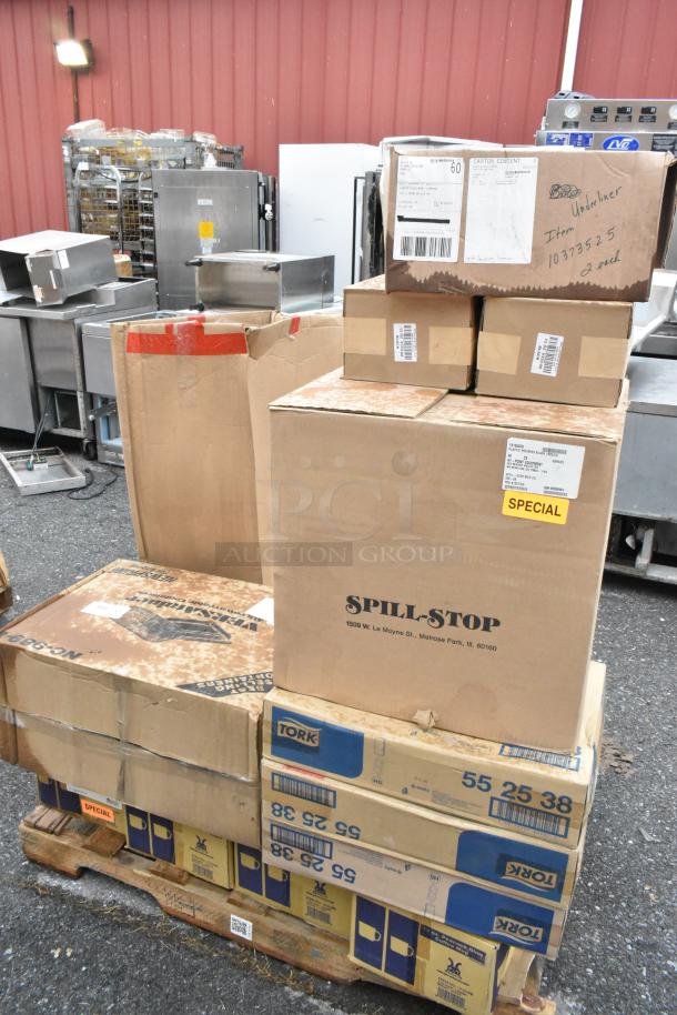 Stack of 21 boxes labeled "Spill-Stop" and "Tork" on a pallet. Contains coffee mugs, pizza peels, pourers; scratch and dent condition.