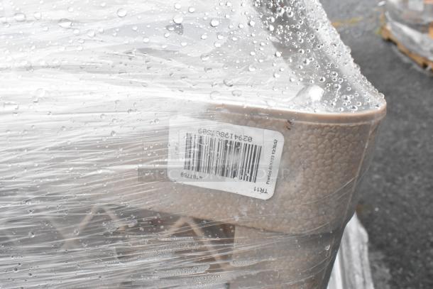 Shrink-wrapped pallet of scratch-and-dent boxes containing plates, glasses, and utensils. Visible barcode label.
