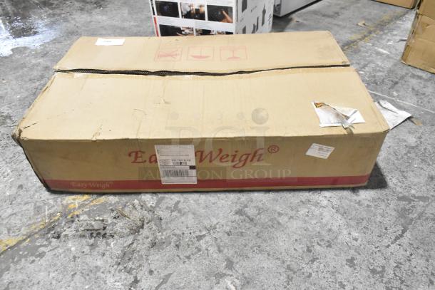 Cardboard box labeled "Easy Weigh" containing a brand new BX-300 Scale, featuring scratches and dents on the packaging.
