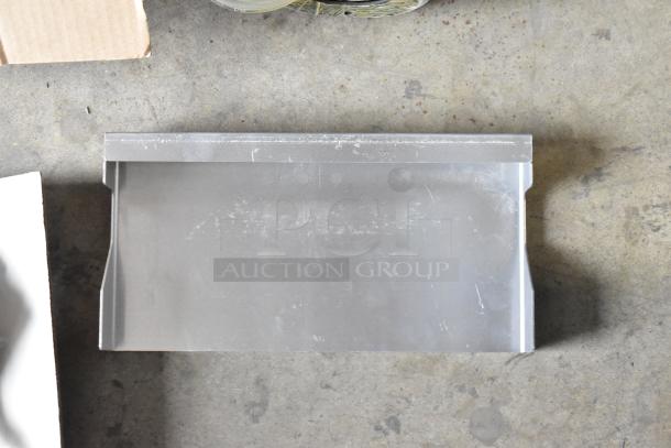 Stainless steel part on concrete floor, likely a component of the Perlick DDS36 kegerator, in new but scratched condition.