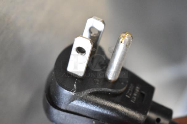 Close-up image of a three-prong electric plug.