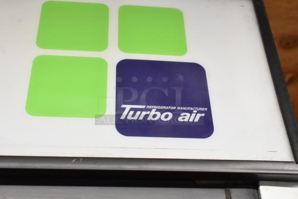 Turbo Air TGM-48R cooler logo, showing brand label with green and blue design on a metal commercial unit.