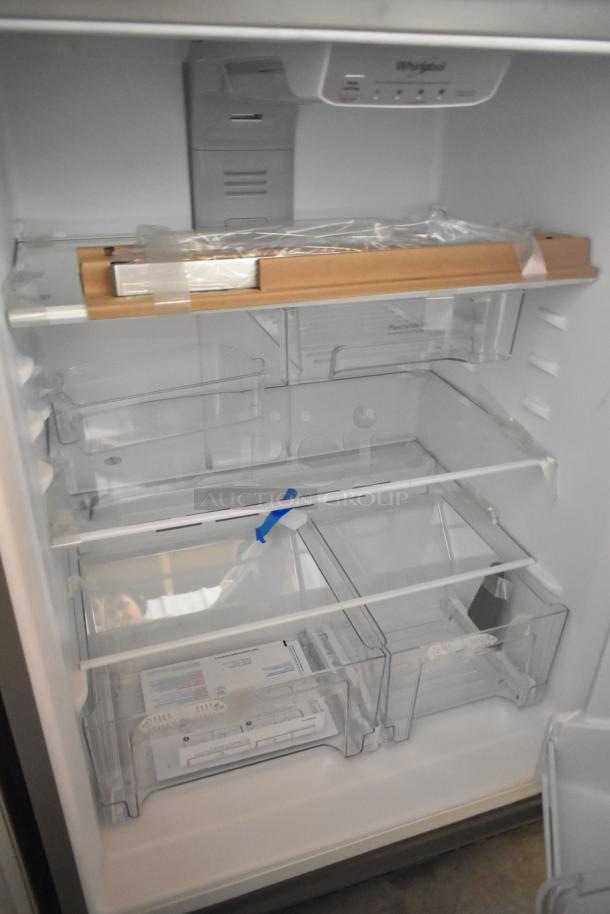Brand new Whirlpool WRT511SZDM00 stainless steel cooler with freezer, 115V, interior view showing shelves and packaging. Scratch and dent condition.