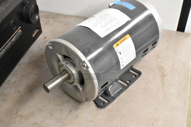 Brand new US Motors Polyphase General Motor, 200-230/480 Volt, with warning label; shown on a metal base.