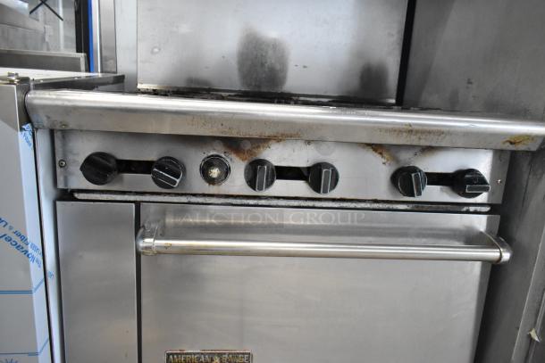 American Range AR-6 stainless steel commercial range with 6 burners, oven, salamander cheese melter, and backsplash. Signs of use visible.