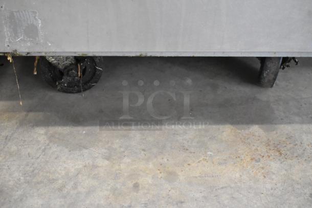 Beverage Air ER24-1AS stainless steel cooler base, visible commercial casters on concrete floor, used condition.