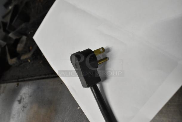 Black electrical plug with two prongs, part of the Beverage Air ER24-1AS cooler's power cord, shown on a white surface.