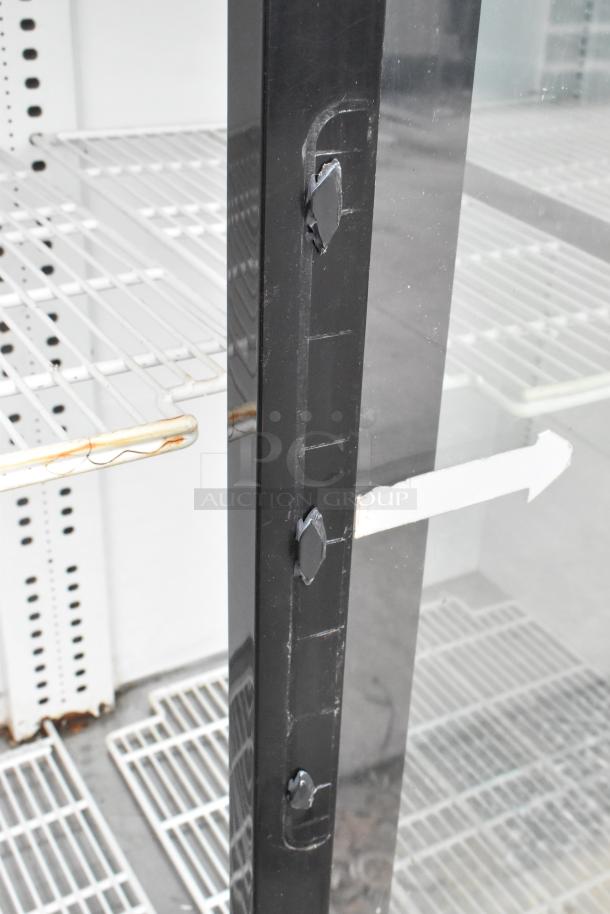 Turbo Air TGM-69R commercial cooler with three glass doors, poly-coated racks, and visible wear on shelving. 115V, 1 Phase.