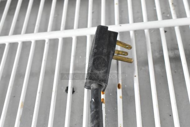 True TAC-48GS-LD metal commercial plug and wiring on white shelving prepped for auction, showing rust spots.