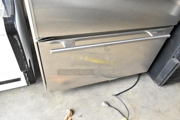 Sub Zero 650/S 2 stainless steel cooler with freezer drawer, shows use, 115 volts, 1 phase, visible handle, plugged cord.