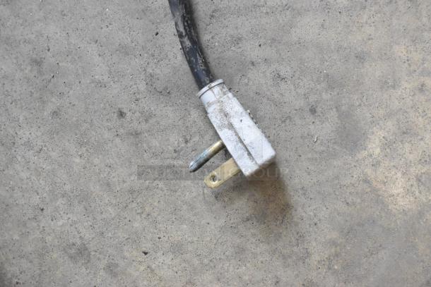 Power plug detail of a True GDM-26EM commercial cooler. Slightly worn condition. Voltage: 115 Volts, 1 Phase.