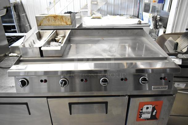 Garland stainless steel commercial gas flat top griddle, multiple control knobs, built-in grease trap, excellent condition.