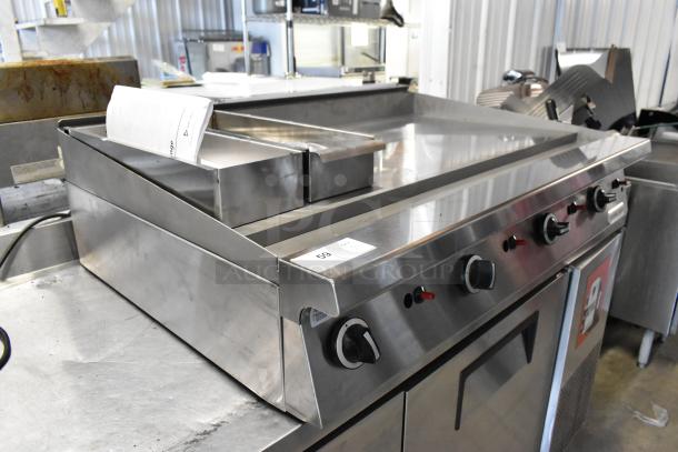 Garland stainless steel commercial gas flat top griddle, with control knobs and drip tray, in good condition.