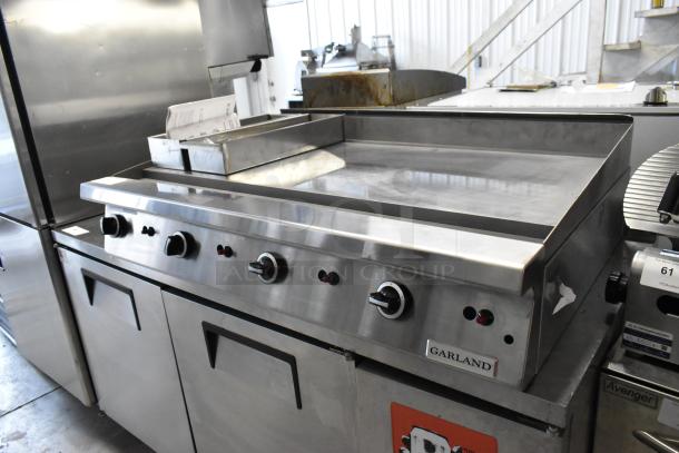 Garland stainless steel commercial gas flat top griddle with control knobs, clean condition, Garland branding visible.