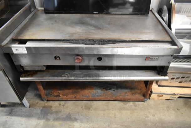 Wolf stainless steel commercial gas griddle on stand, used condition, visible rust on stand, model label intact.