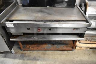Wolf stainless steel commercial gas griddle on stand, used condition, visible rust on stand, model label intact.