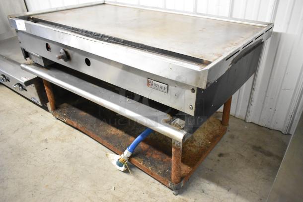 Wolf stainless steel commercial gas flat top griddle on equipment stand. Features visible Wolf branding. Used condition.