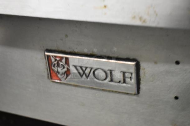 Wolf stainless steel commercial gas flat top griddle on stand, logo visible.