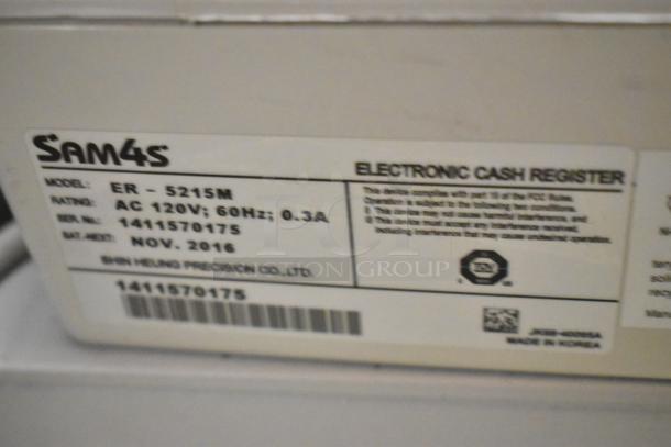 Sam4s ER-5215M countertop electronic cash register label. Model, voltage, and manufacturing details visible.
