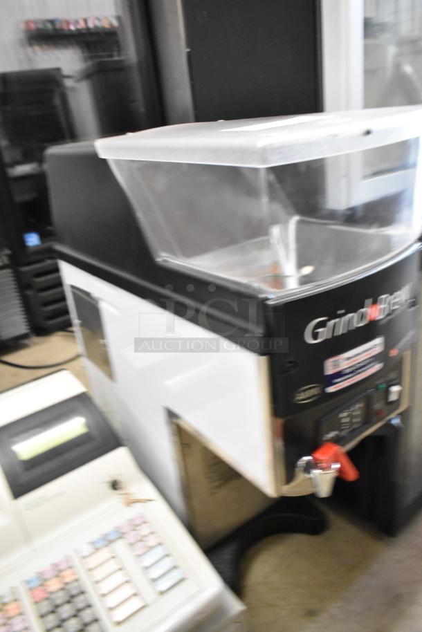 Brand new Grindmaster Grind'n Brew-10H stainless steel coffee grinder and maker with hot water dispenser and metal brew basket.
