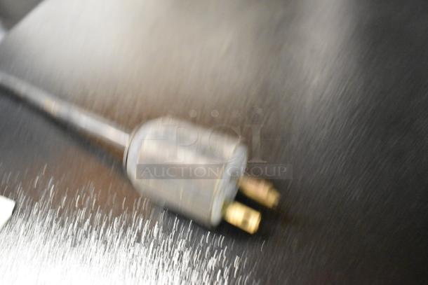 Electric plug of a Fujee HFS-350S Metal Commercial Meat Slicer, showing three prong connector on dark surface. 220 volts.