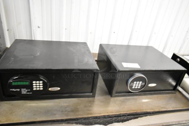 Two black metal single compartment safes, keypad entry, no combinations included, slight wear visible.