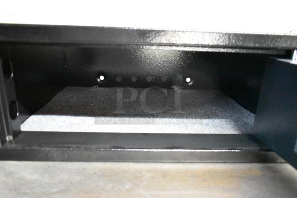 Two black metal single compartment safes, no combinations included, solid construction, interior view shown.